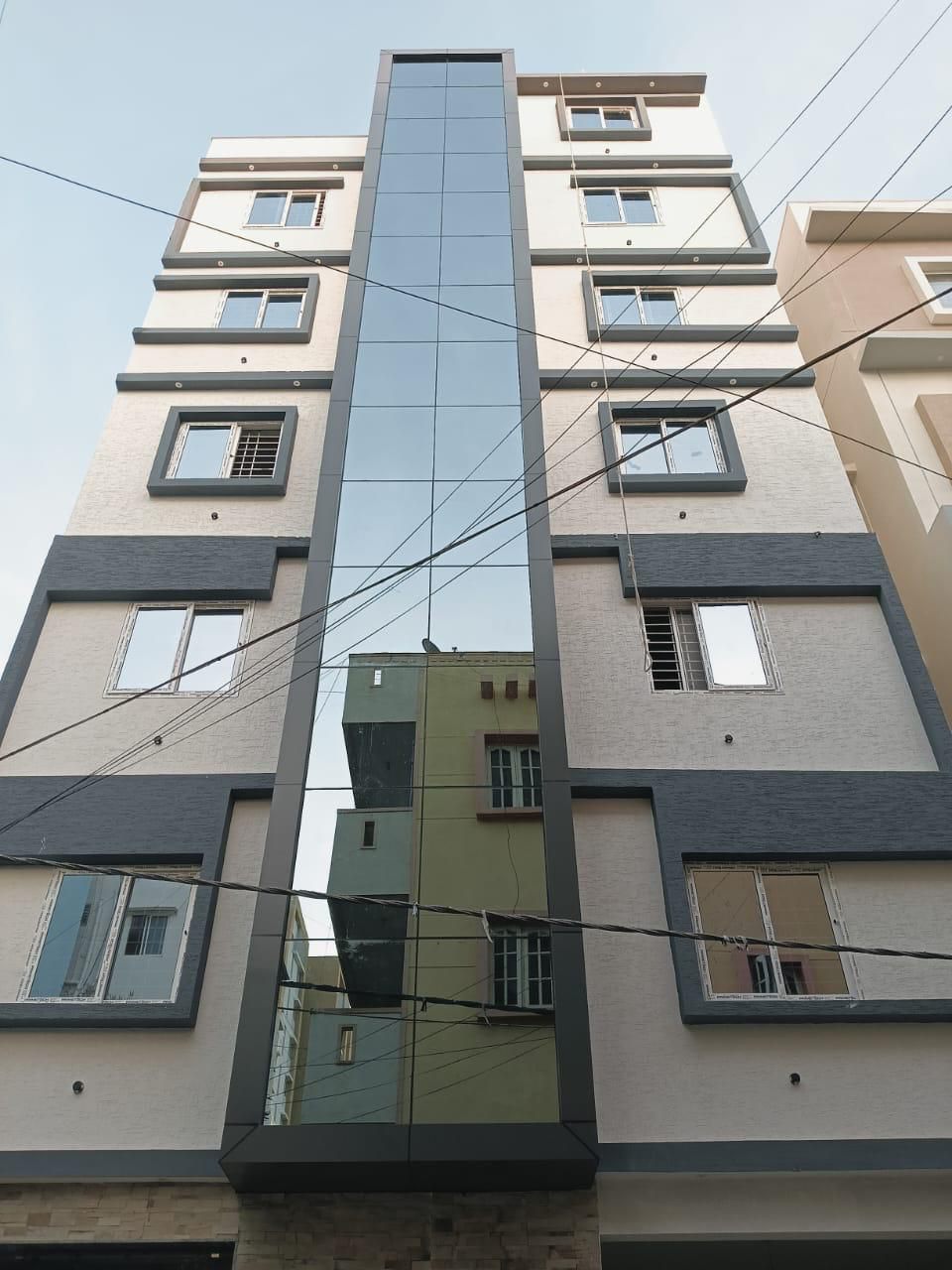Multi-Floor Building with Central Structural Glass & Flanking uPVC Windows
