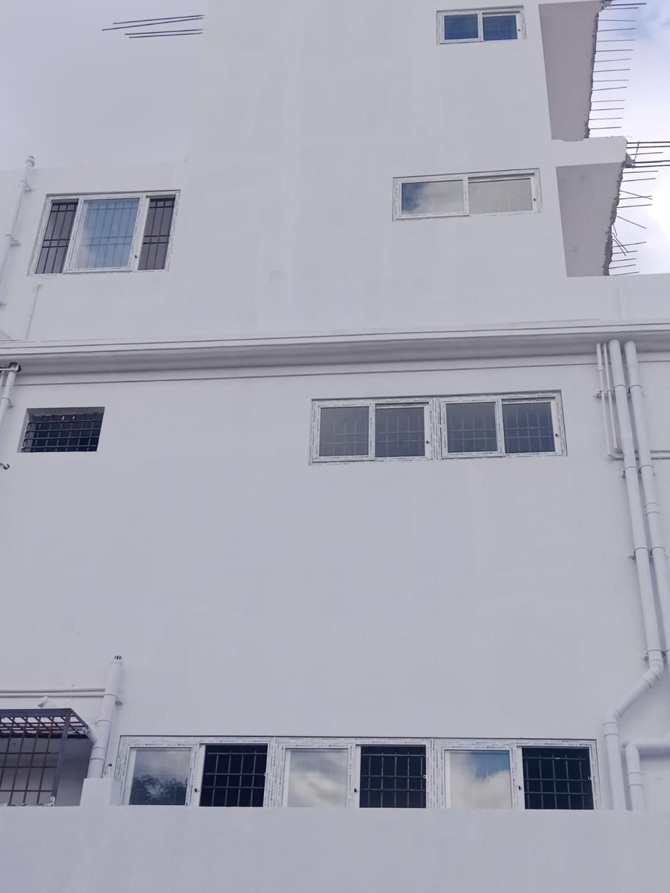 Four-Storey White Residential Building with Modern uPVC Sliding Windows